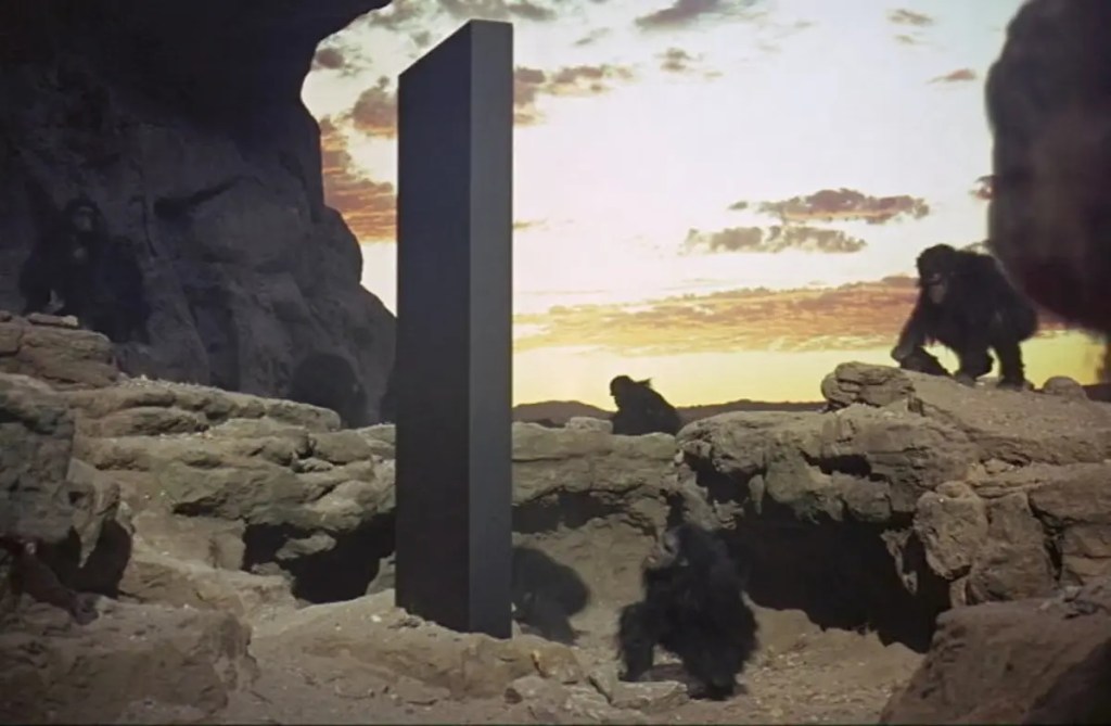 First scene of the movie 2001: A Space Odyssey, a black monolith and monkeys around